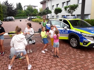 Na zdjęciu widzimy policjantów oraz uczestników półkolonii