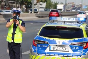 Na zdjęciu widzimy policjanta oraz radiowóz