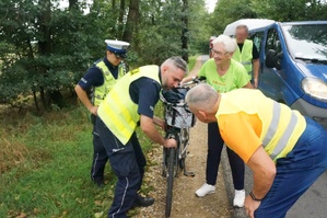 Na zdjęciu widzimy jak policjanta pomaga starszej Pani