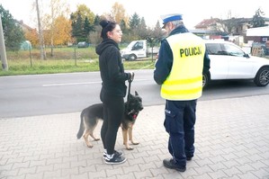 Na zdjęciu widzimy policjanta jak daje odblask