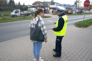 Na zdjęciu widzimy policjanta jak daje odblask