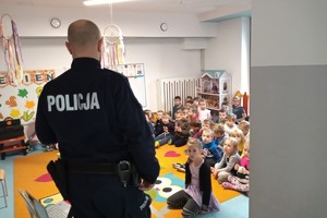 Na zdjęciu widzimy przedszkolaki oraz policjanta