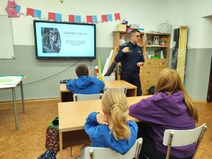 Na zdjęciu widzimy policjanta w czasie pogadanki z uczniami