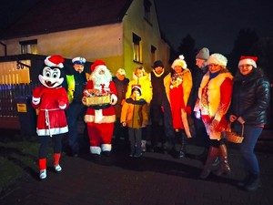 Na zdjęciu widzimy policjanta Mikołaja oraz wolontariuszy