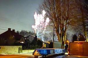 Na zdjęciu widzimy sztuczne ognie oraz napis Policja