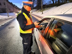 Na zdjęciu widzimy policjanta w czasie badania stanu trzeźwości