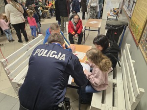 Na zdjęciu widzimy policjanta oraz uczestników w czasie 33. Finału Wielkiej Orkiestry Świątecznej Pomocy