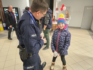 Na zdjęciu widzimy policjanta oraz uczestników w czasie 33. Finału Wielkiej Orkiestry Świątecznej Pomocy