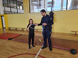 Na zdjęciu widzimy policjanta w czasie rozdawania nagród