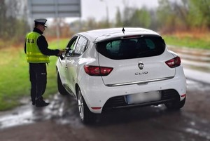 Na zdjęciu widzimy policjanta w czasie kontroli stanu trzeźwości kierującego