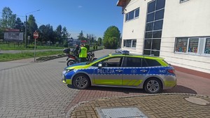 Na zdjęciu widzimy policjanta, radiowóz oraz motocyklistów w czasie kontroli