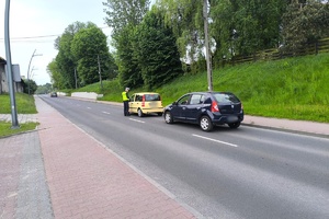Na zdjęciu widzimy policjanta oraz samochody w czasie kontroli stanu trzeźwości