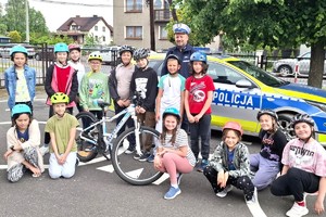 Na zdjęciu widzimy policjanta oraz uczniów klasy czwartej w czasie egzaminu na kartę rowerową