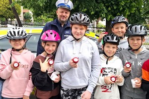 Na zdjęciu widzimy policjanta oraz uczniów klasy czwartej w czasie egzaminu na kartę rowerową