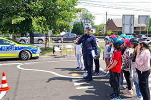 Na zdjęciu widzimy policjanta oraz uczniów klasy czwartej w czasie egzaminu na kartę rowerową