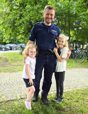 Na zdjęciu widzimy policjanta oraz dzieci w czasie profilaktyki w czasie dnia dziecka