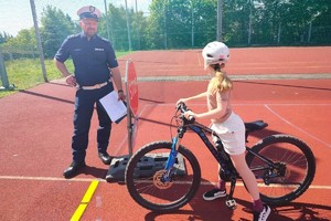 NA zdjęciu widzimy policjanta oraz ucznia w czasie egzaminu na kartę rowerową