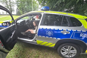 Na zdjęciu widzimy radiowóz wraz z dziećmi