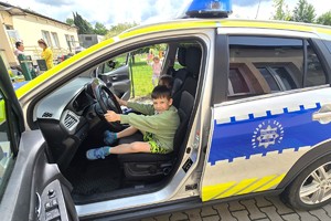 Na zdjęciu widzimy dziecko siedzące w radiowozie