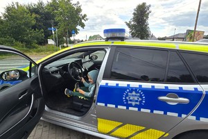 Na zdjęciu widzimy siedzące dziecko w radiowozie