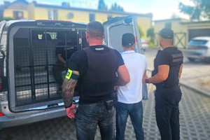 Na zdjęciu widzimy zatrzymanego oraz funkcjonariuszy Policji i Straży Granicznej
