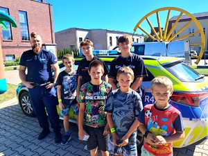 Na zdjęciu widzimy policjanta oraz dzieci