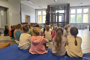 Na zdjęciu widzimy policjanta w czasie pogadanki z uczniami