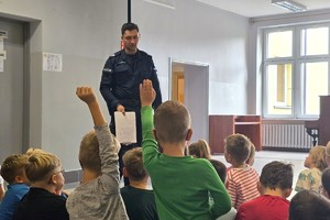 Na zdjęciu widzimy policjanta w czasie pogadanki z uczniami