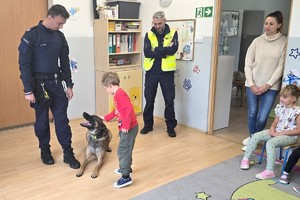 Na zdjęciu widzimy psa służbowego oraz dzieci