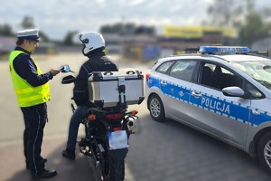 Na zdjęciu widzimy policjanta w czasie kontroli kierującego jednośladem