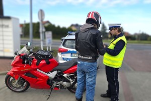 Na zdjęciu widzimy policjanta w czasie kontroli kierującego jednośladem