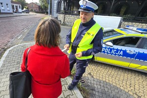 Na zdjęciu widzimy policjanta dającego odblask