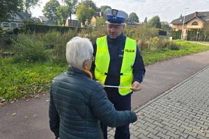 Na zdjęciu widzimy policjanta dającego odblask