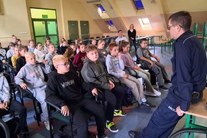 Na zdjęciu widzimy policjanta w czasie pogadanki z czwartoklasistami