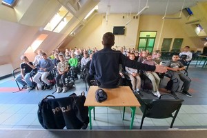Na zdjęciu widzimy policjanta w czasie pogadanki z czwartoklasistami