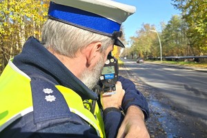 Na zdjęciu widzimy policjanta w czasie kontroli prędkości