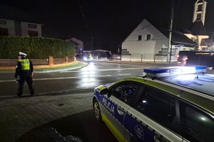 Na zdjęciu widzimy policjanta oraz radiowóz