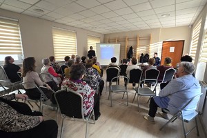 Na zdjęciu widzimy policjanta oraz seniorów w czasie debaty