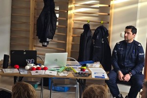 Na zdjęciu widzimy policjanta oraz seniorów w czasie debaty