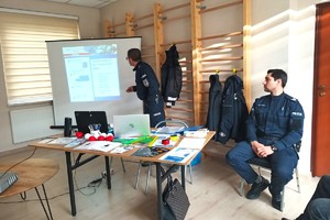 Na zdjęciu widzimy policjanta oraz seniorów w czasie debaty