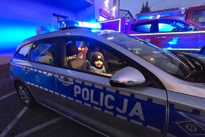 Na zdjęciu widzimy policjanta rozdającego odblaski