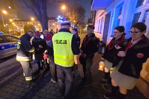 Na zdjęciu widzimy policjanta rozdającego odblaski