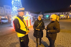 Na zdjęciu widzimy policjanta rozdającego odblaski