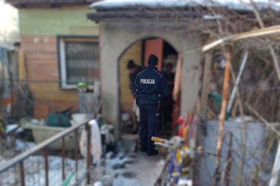 Na zdjęciu widzimy policjanta przekazującego najpotrzebniejsze rzeczy osobą w kryzysie bezdomności