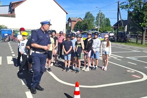 Na zdjęciu widzimy policjanta oraz uczniów w czasie egzaminu na kartę rowerową