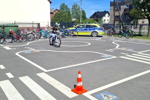 Na zdjęciu widzimy policjanta oraz uczniów w czasie egzaminu na kartę rowerową