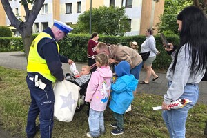 Na zdjęciu widzimy policjanta rozdającego prezenty  w czasie Moto Bajkowego Dnia Dziecka