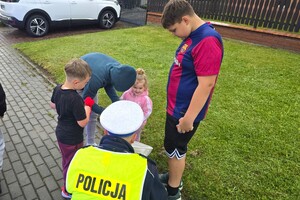 Na zdjęciu widzimy policjanta rozdającego prezenty  w czasie Moto Bajkowego Dnia Dziecka