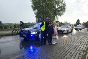 Na zdjęciu widzimy policjanta rozdającego prezenty  w czasie Moto Bajkowego Dnia Dziecka
