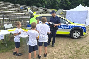 Na zdjęciu widzimy uczestników oraz policjanta w czasie XXV Powiatowe Igrzyska Osób Niepełnosprawnych